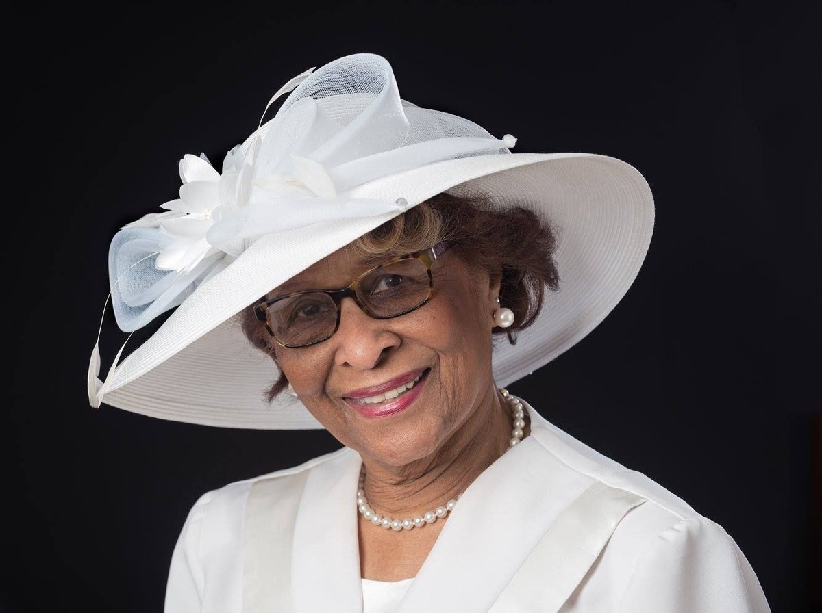Woman over 70 with white Hat Over Tidy Curls — church and Sunday hairstyle for women over 70