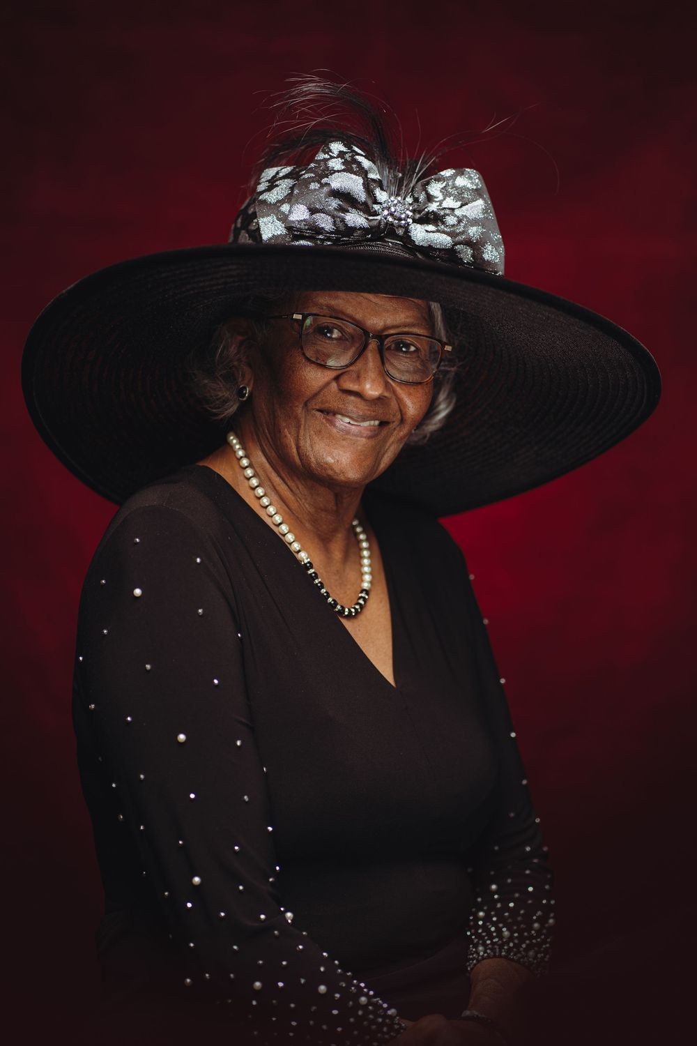 Woman over 70 with black Wide-Brim Hat, Hair Tucked Neat — church and Sunday hairstyle for women over 70