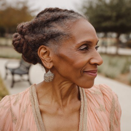 Woman over 70 with soft Twisted Updo with Drop Earrings — church and Sunday hairstyle for women over 70