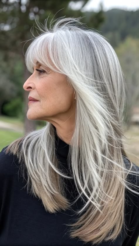 Woman over 70 with a long white layers in profile — face-lifting haircut with soft layers for women over 70