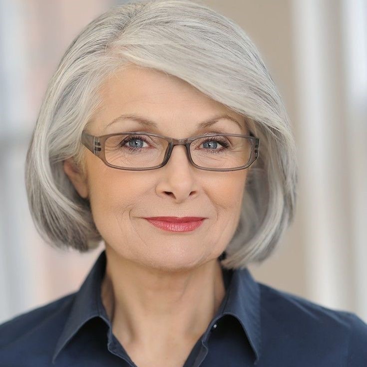 woman over 70 with a smooth silver bob wearing rectangular glasses