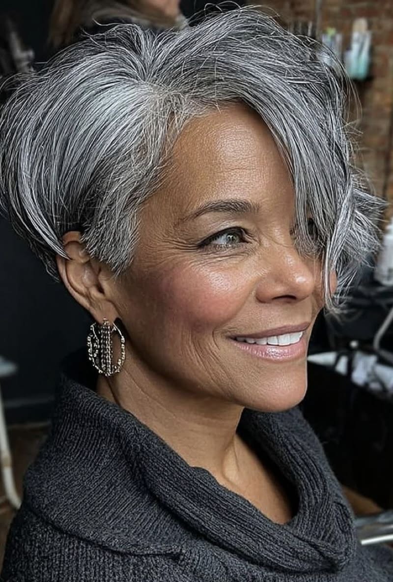 Woman over 70 with a silver swept pixie — gray pixie hairstyle with soft texture for women over 70