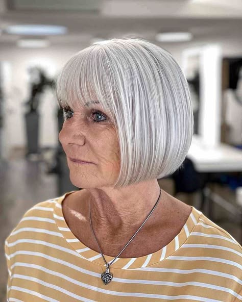 Woman over 70 with blunt bob with a sleek, straight fringe — flattering bangs hairstyle for women over 70