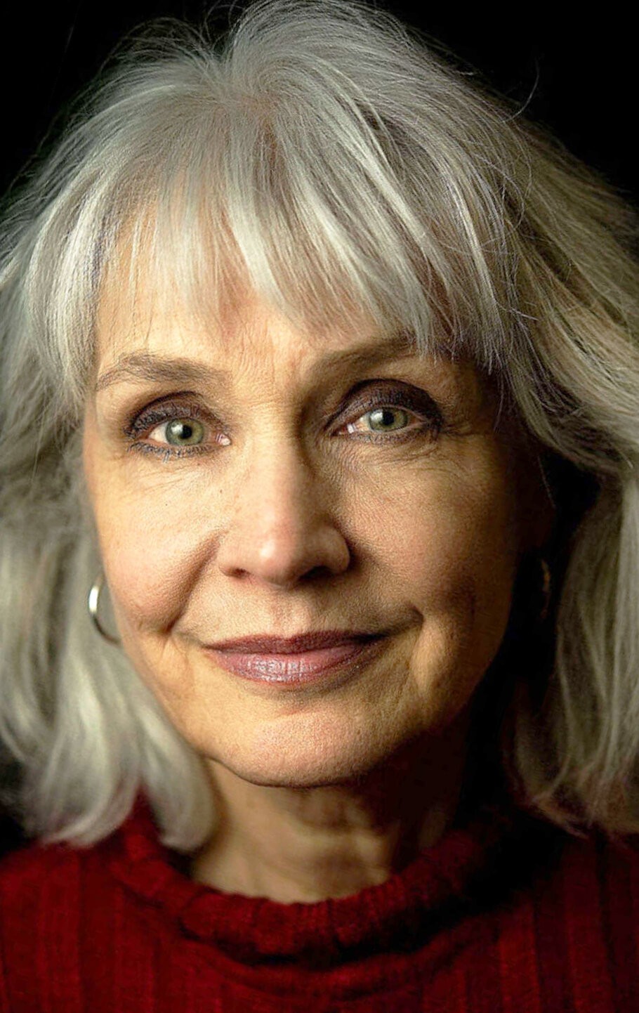 Woman over 70 with medium layers with light, wispy bangs — flattering bangs hairstyle for women over 70