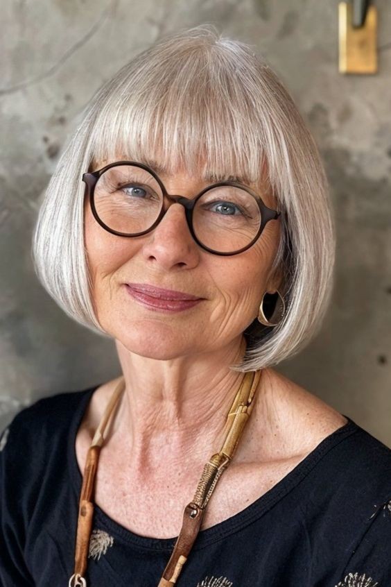 Woman over 70 with rounded bob with full bangs and round glasses — flattering bangs hairstyle for women over 70