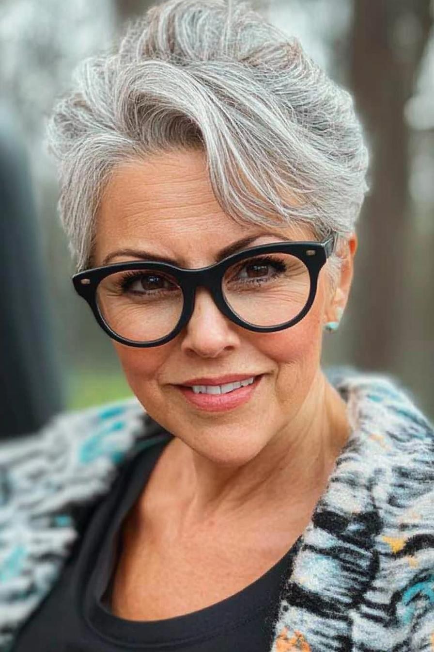 woman over 70 with long silver hair wearing round gray glasses