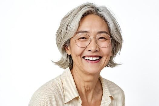 smiling Asian woman over 70 with a feathered gray bob wearing wire glasses