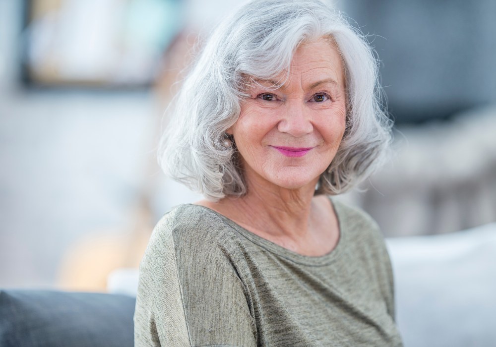 The Gentle Wavy Bob With a Soft Fringe — layered bob on thick wavy hair on a woman over 70