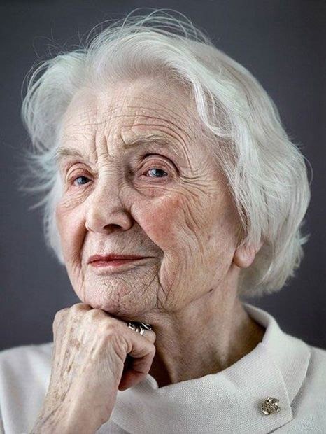 The Wavy White Bob With Gentle Layers — layered haircut that slims a round face on a woman over 70