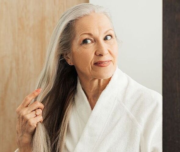 Woman over 70 with long Hair Brushed Smooth With Dark Silver Streaks — long hairstyle inspiration for women over 70