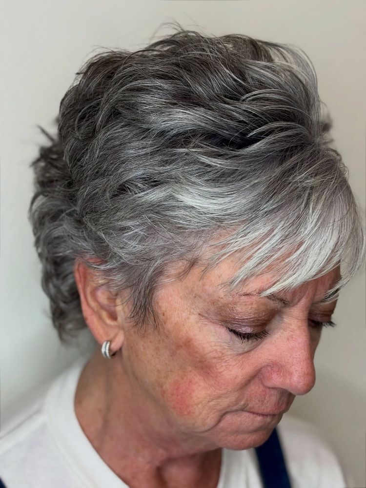 Steel-Gray Layers With Darker Natural Roots — lowlights for gray hair on a woman over 70 adding depth while hair stays mostly silver