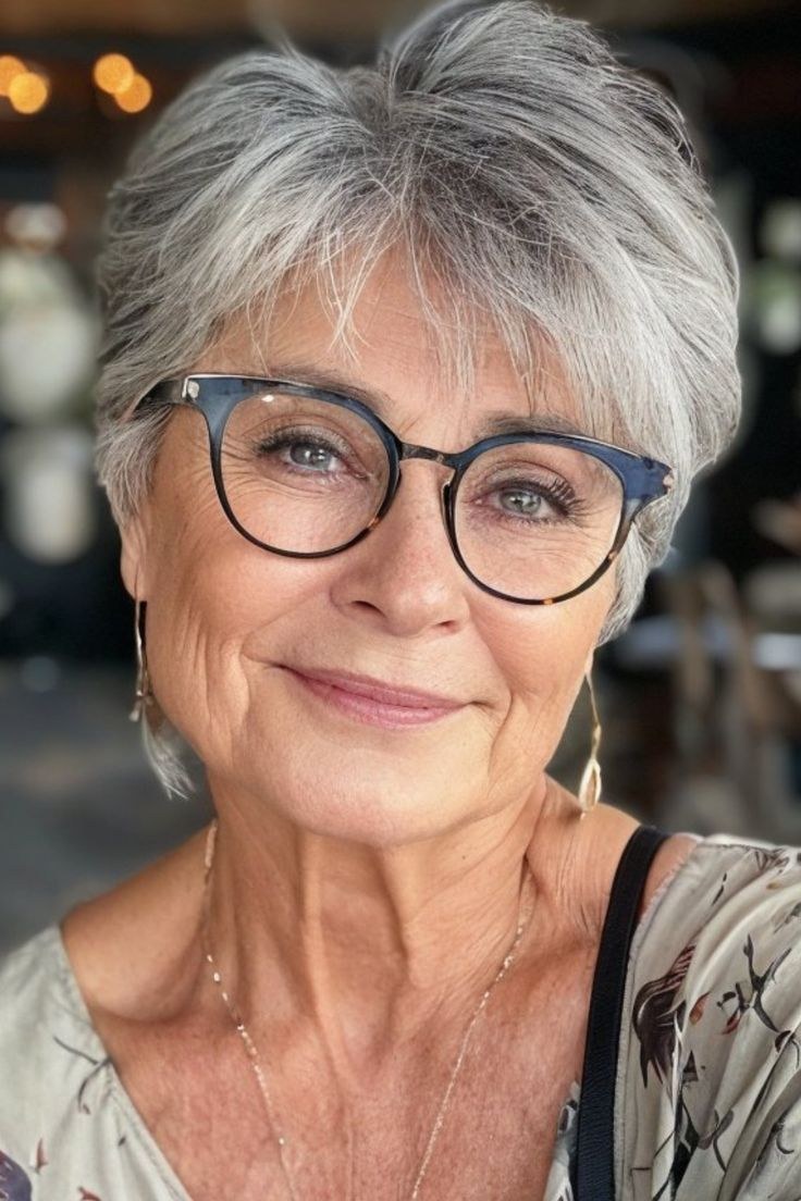 Woman over 70 with a textured pixie worn with bold glasses — modern haircut for women over 70