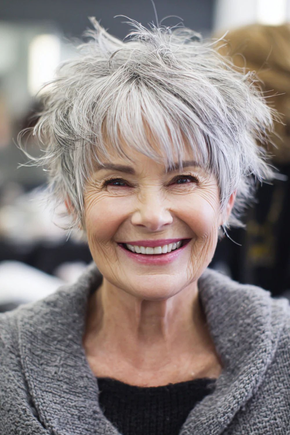 Woman over 70 with a tousled pixie with a big smile — modern haircut for women over 70