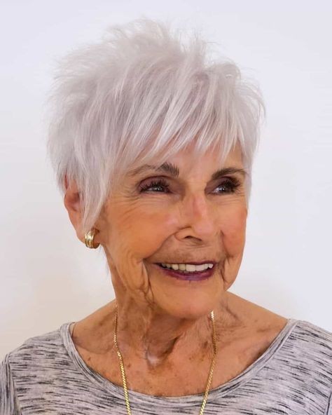 Woman over 70 with a feathered white pixie for fine hair — short easy haircut for women over 70