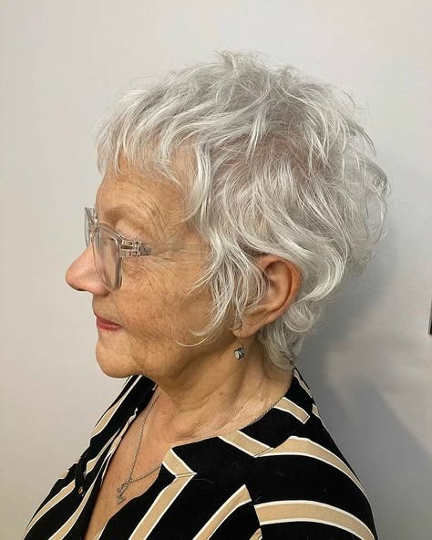 Woman over 70 with a curly gray crop worn with glasses — short easy haircut for women over 70