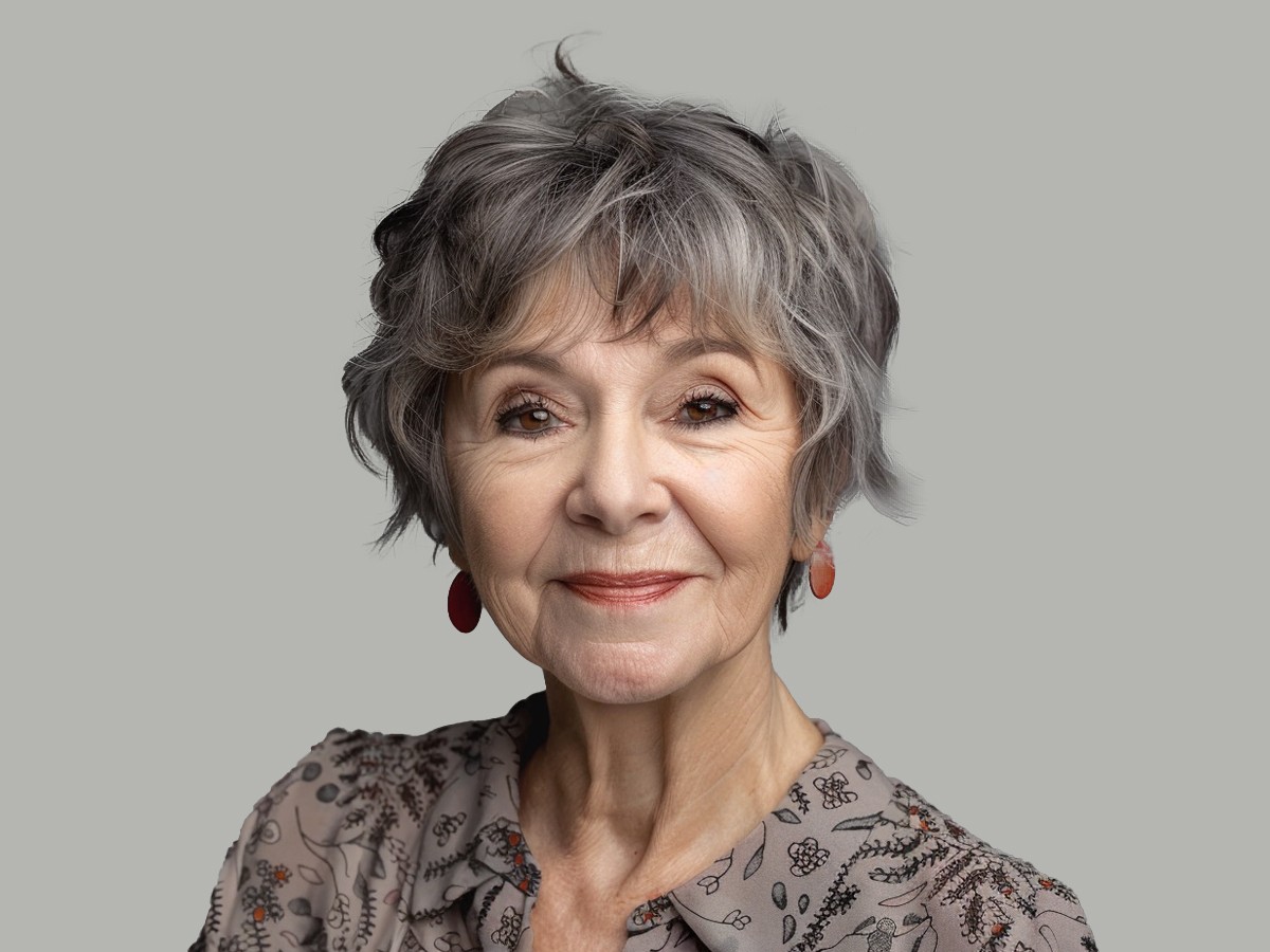 Woman over 70 with short curly crop with a natural fringe — flattering bangs hairstyle for women over 70