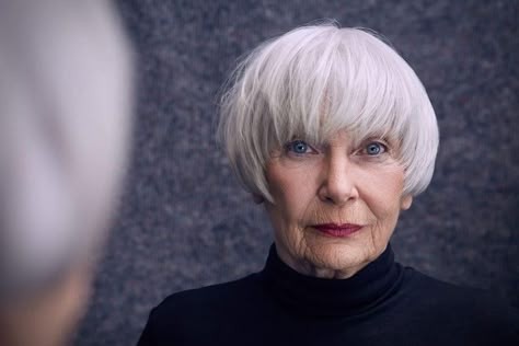 Woman over 70 with white bowl bob with a smooth, full fringe — flattering bangs hairstyle for women over 70