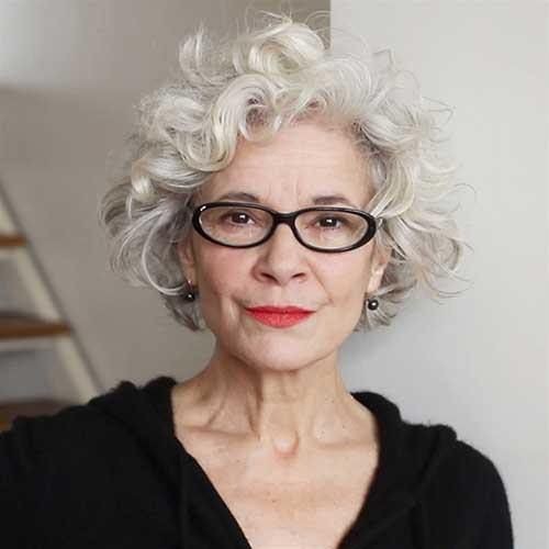 woman over 70 with a curly white crop wearing slim black glasses