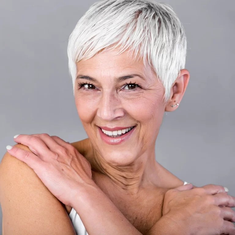 Woman over 70 with a bright white pixie with a long fringe — short hairstyle for women over 70