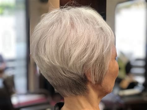 Woman over 70 with a soft white tapered crop — short layered haircut back view for women over 70