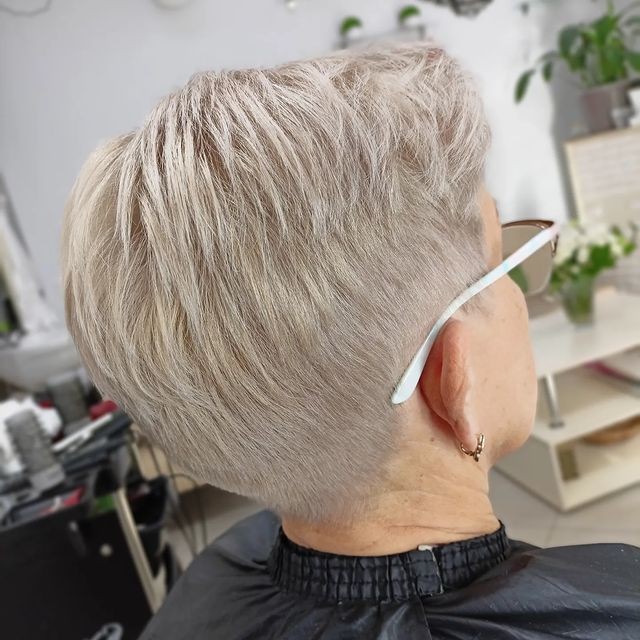 Woman over 70 with a tapered pixie cut clean above the ear — short layered haircut back view for women over 70