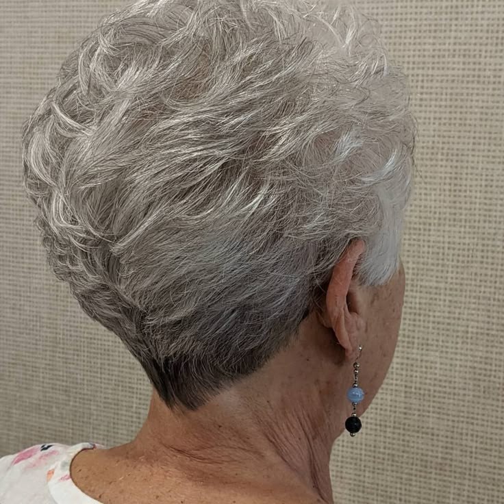 Woman over 70 with a curly tapered crop — short layered haircut back view for women over 70