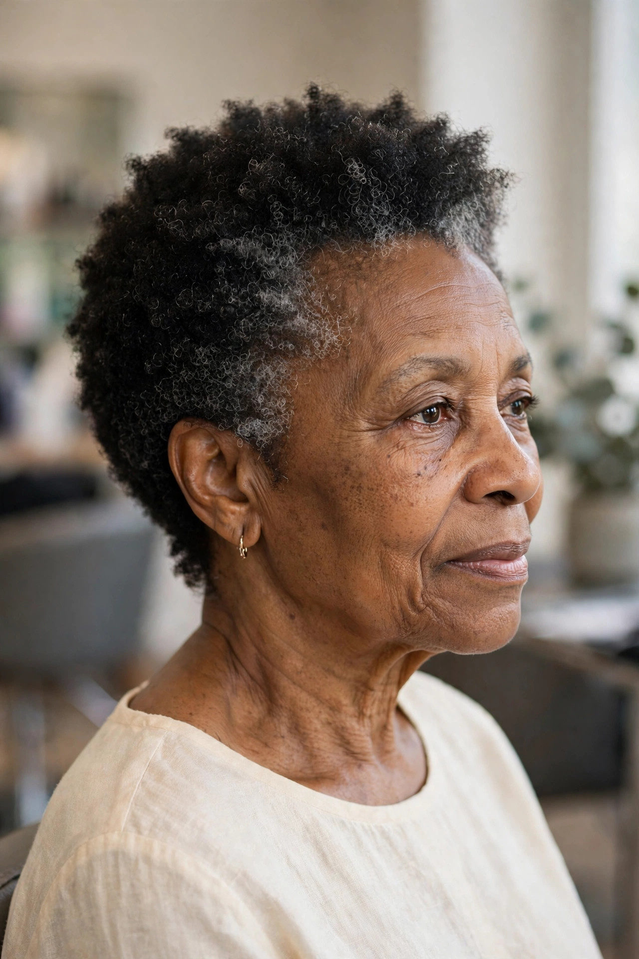 Low Taper with a Soft Coily Top - short tapered natural haircut on a Black woman over 60