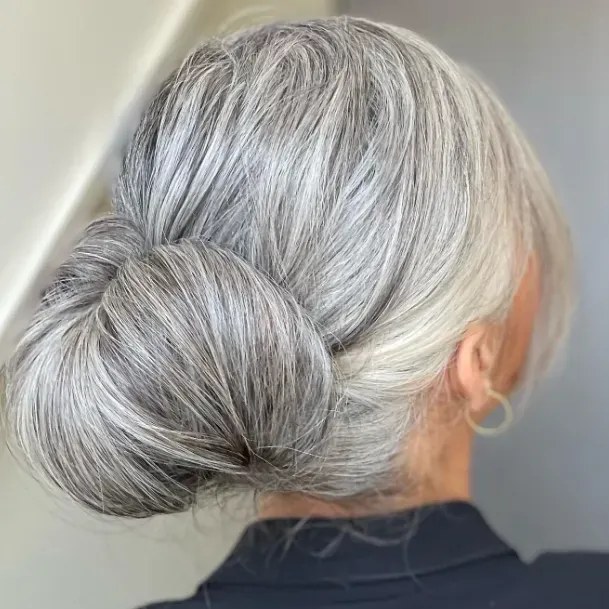 Woman over 70 with double-Coil Bun — simple bun hairstyle for long gray hair inspiration for women over 70