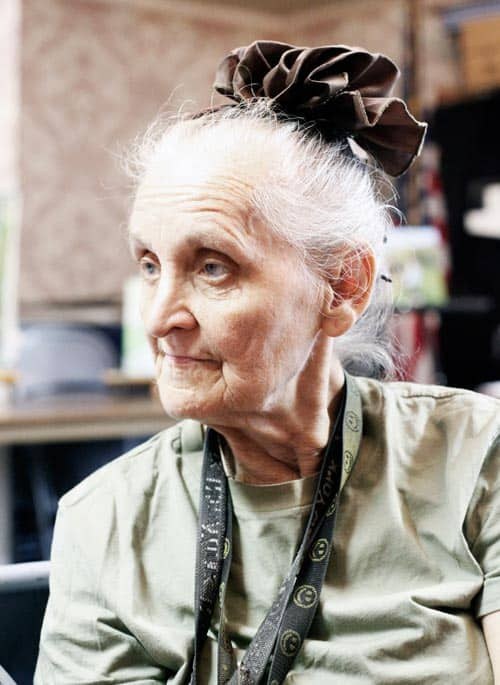 Woman over 70 with bun With a Soft Silk Scrunchie — simple bun hairstyle for long gray hair inspiration for women over 70