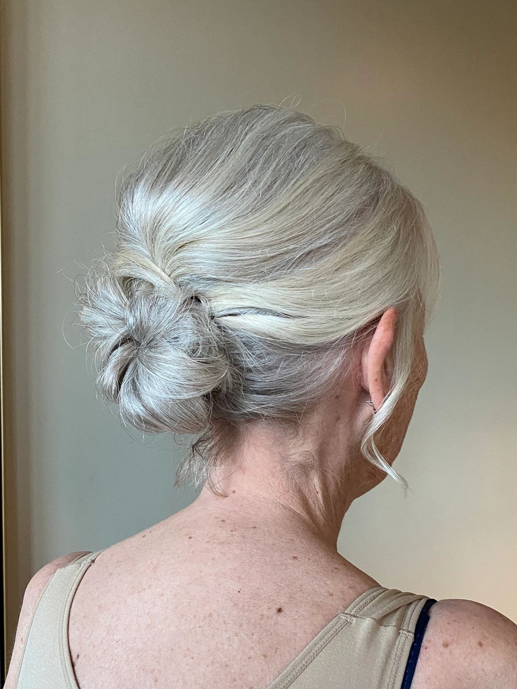Woman over 70 with easy Twisted Bun — simple bun hairstyle for long gray hair inspiration for women over 70