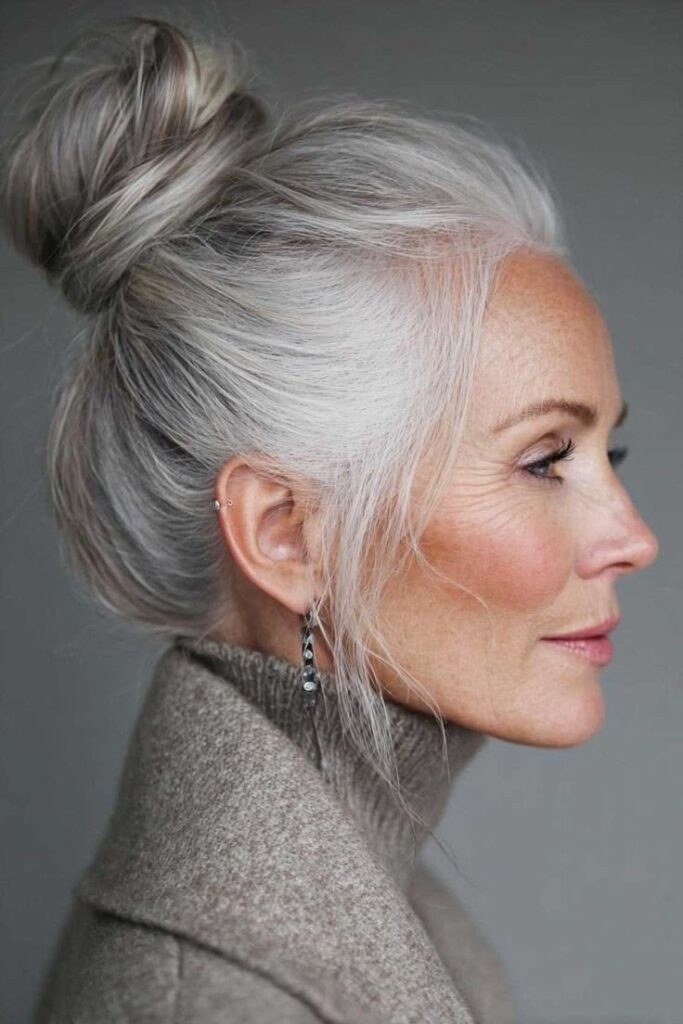 Woman over 70 with classic Top Knot — simple bun hairstyle for long gray hair inspiration for women over 70