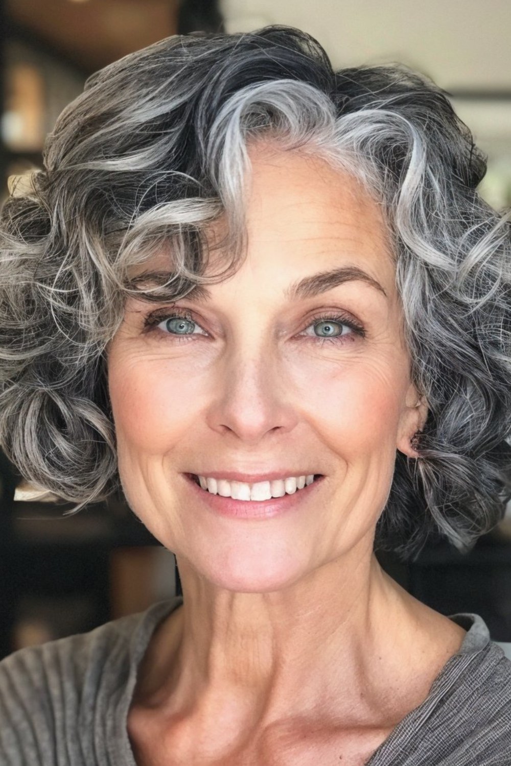 The Dark-and-Silver Curly Bob — softening hairstyle for a square face on a woman over 70