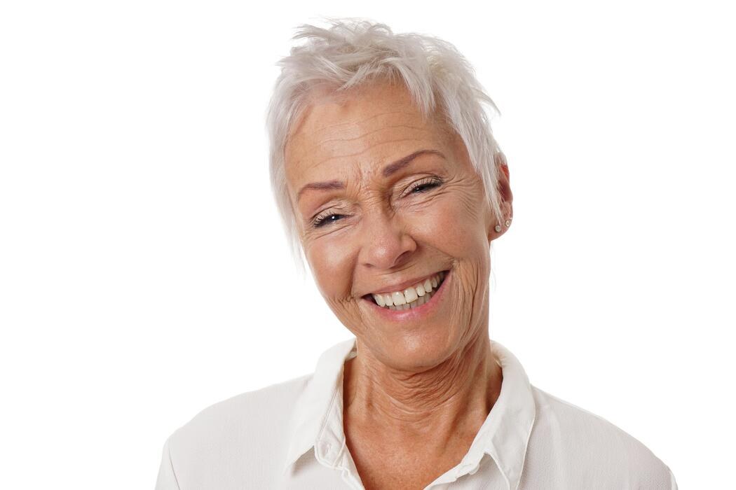 Woman over 70 with bright White Pixie Worn with a Broad Smile — summer short haircut for women over 70