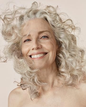 Long Blonde-Gray Curls With Face-Framing Layers — thick hair haircut on a woman over 70